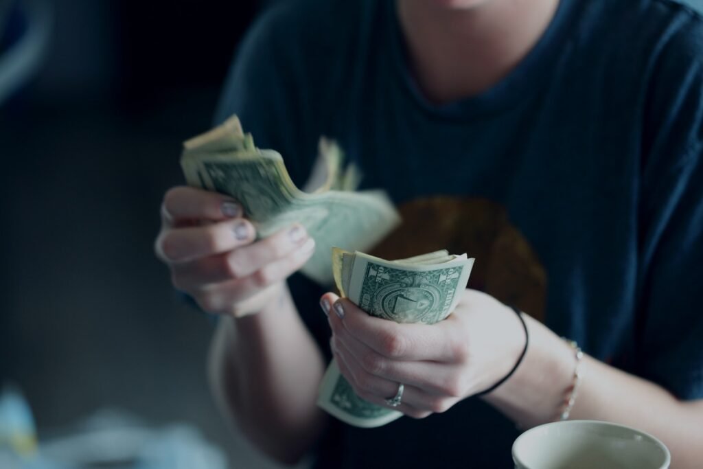 focus photography of person counting dollar banknotes